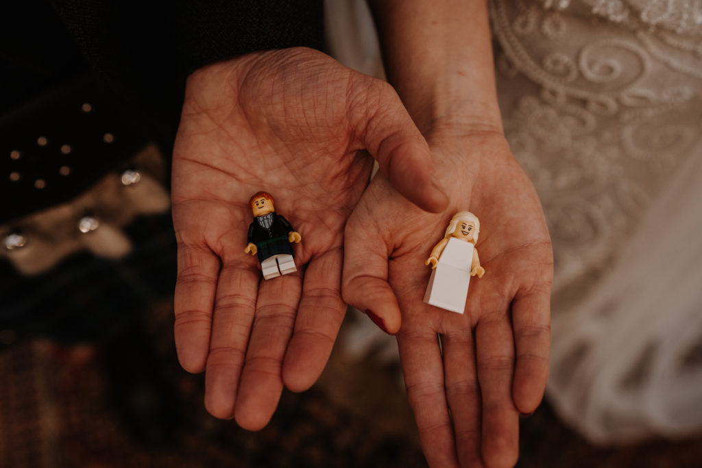 newly weds hold miniature lego versions of a bride and groom